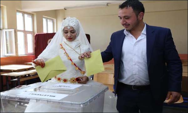 عروسين تركيين يصوتان في الانتخابات البرلمانية